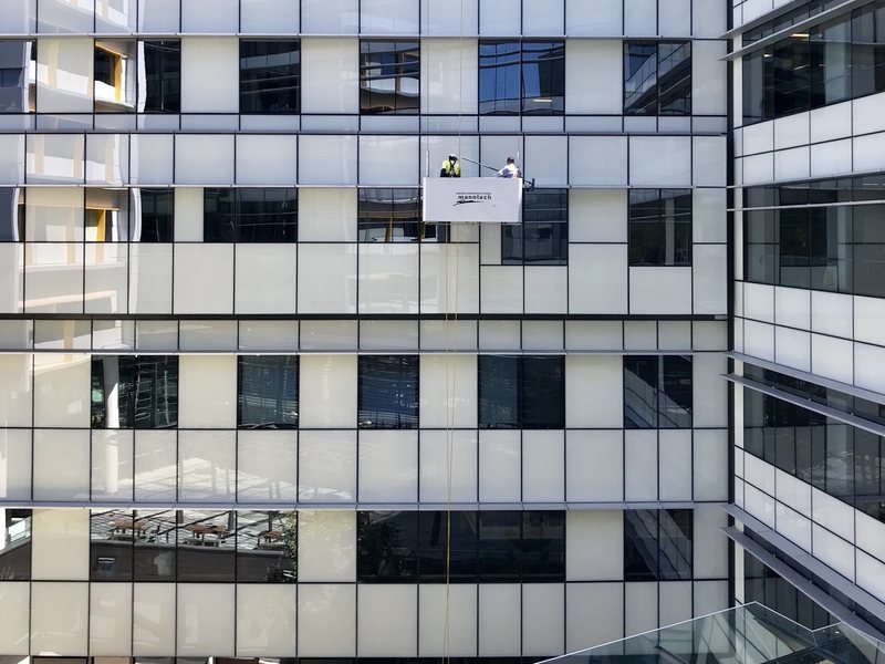 Cradle platform working down the elevation of a high-rise building