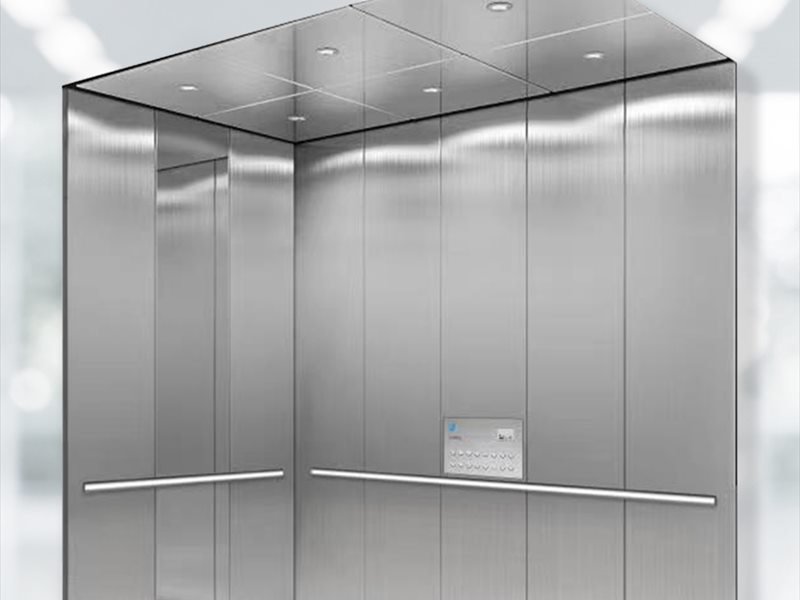Hospital lift car interior with stainless steel walls and handrails